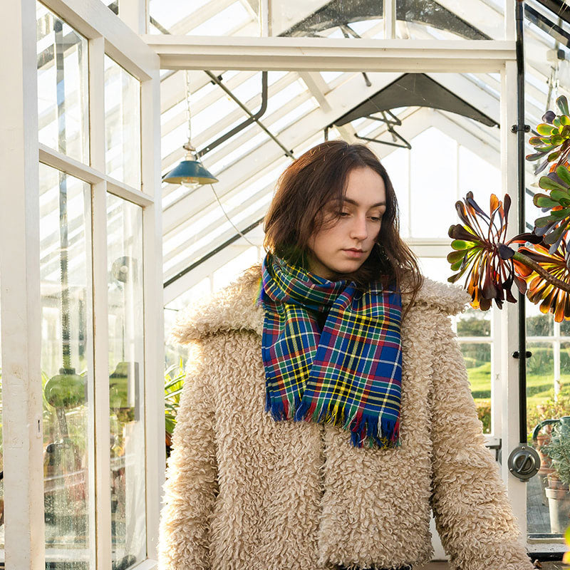 Handmade tartan scarf worn with coat in everyday setting